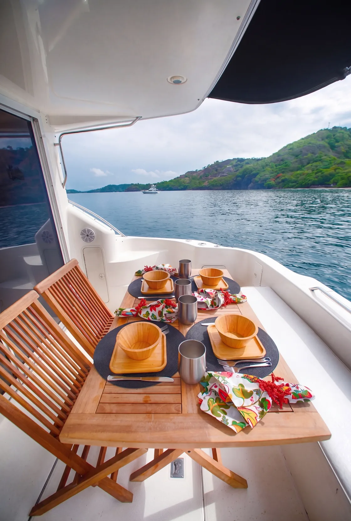 Table set for lunch on the aft deck of a luxury yacht, Papagayo coastline in view