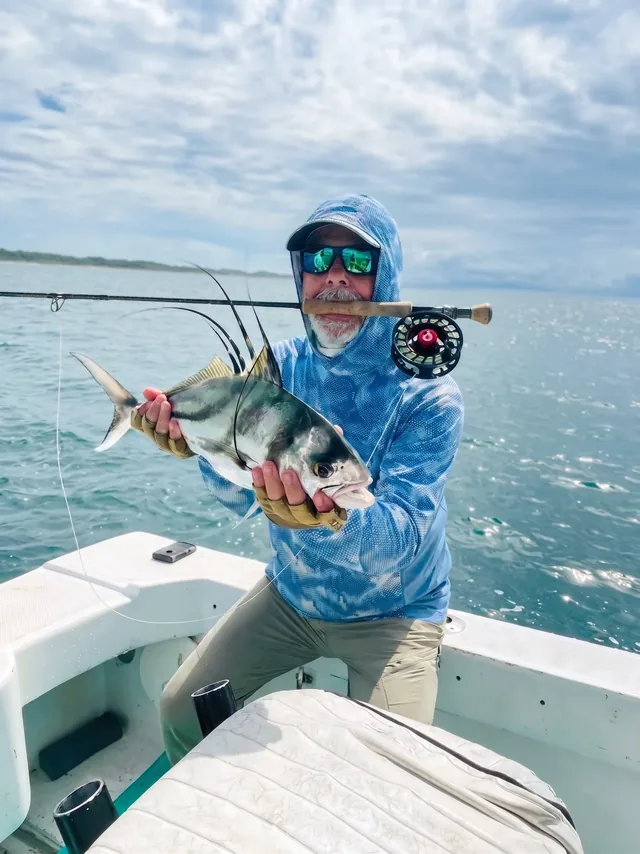 Angler holding a roosterfish caught on a fly rod near Papagayo