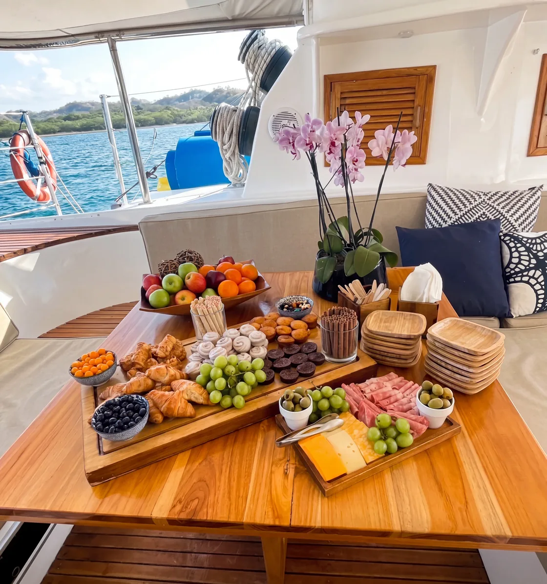 Gourmet fruit and charcuterie spread on the deck of a luxury yacht charter